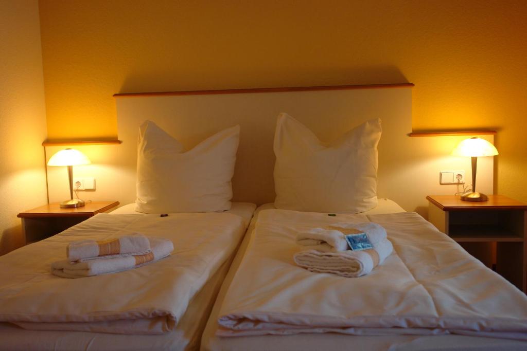 a hotel room with two beds with towels on them at Pension Zeitlos in Potsdam