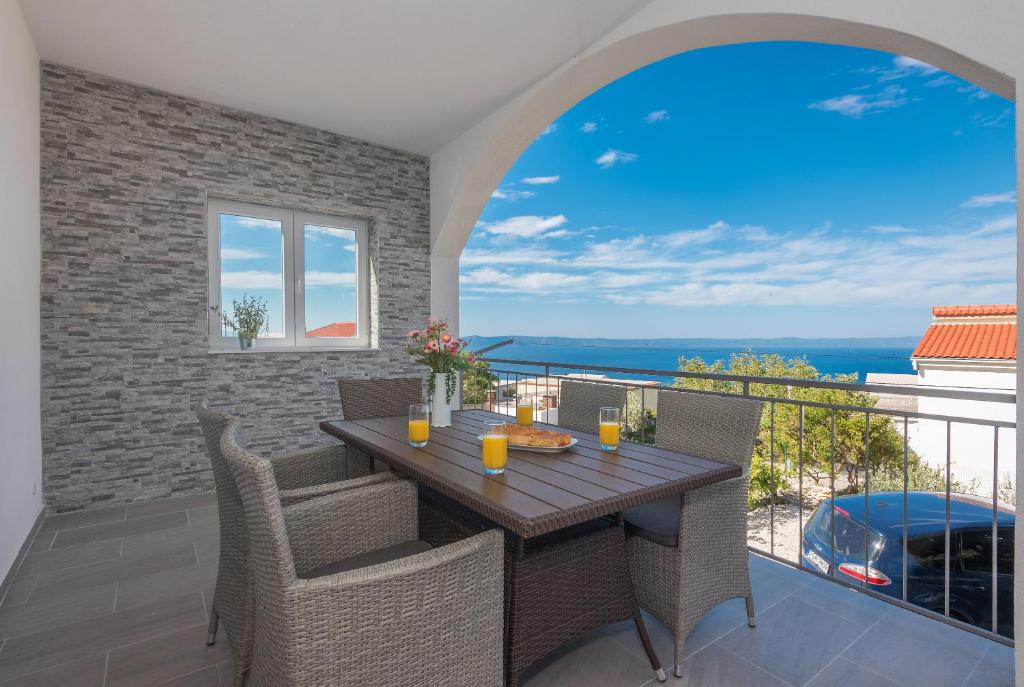 a dining room with a table and chairs on a balcony at Apartman Pinto in Makarska