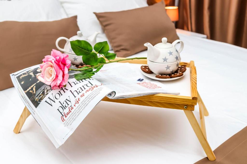 a coffee table with a tea pot and a magazine on a bed at Villa Casa Mia in Sutomore