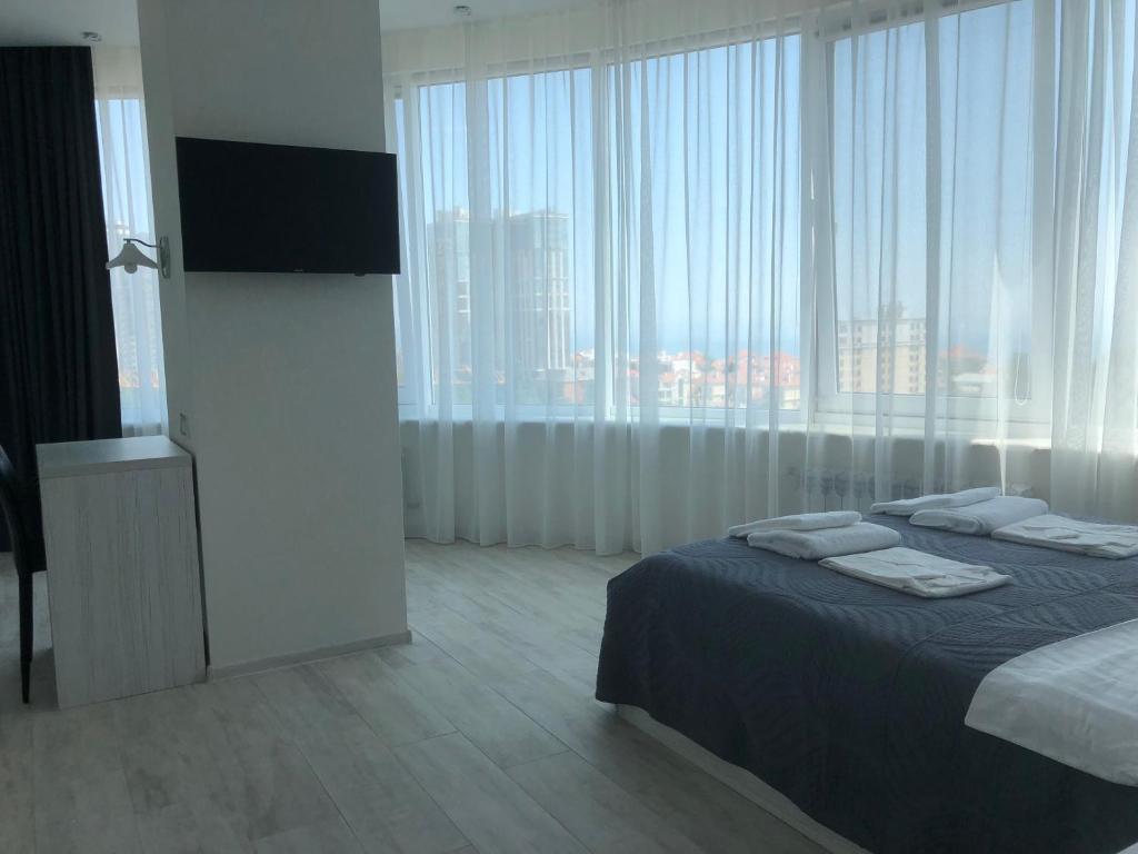 um quarto com uma cama e uma televisão de ecrã plano em The Rooms Apart em Odessa