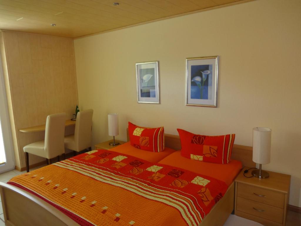 a bedroom with a bed with red pillows and a desk at Ferienwohnung Latscha in Kappel-Grafenhausen