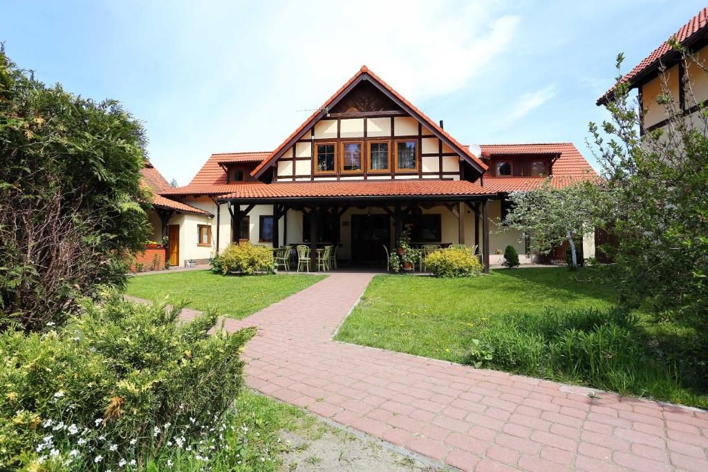 ein Haus mit einem Backsteinsteg davor in der Unterkunft GOŚCINIEC GŁODOWO in Ruciane-Nida
