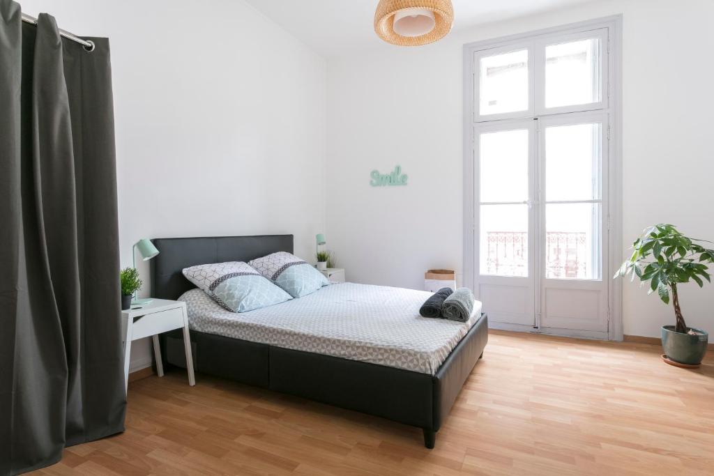 1 dormitorio con cama y ventana grande en Flamingo appartement Diderot 2 Center, en Béziers