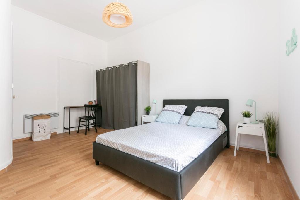 1 dormitorio con 1 cama grande con almohadas azules en Flamingo appartement Diderot 2 Center, en Béziers