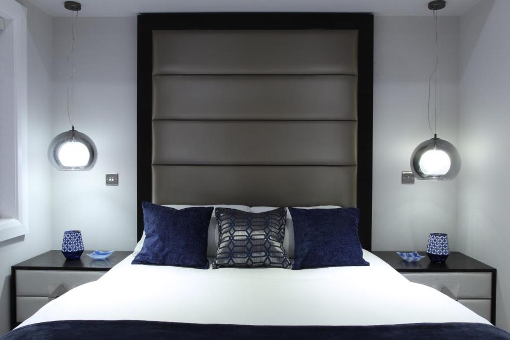 a bedroom with a large bed with two lights above it at Glass Island Ballycastle in Ballycastle
