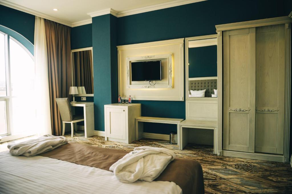 Un pat sau paturi într-o cameră la Emerald Suite Hotel