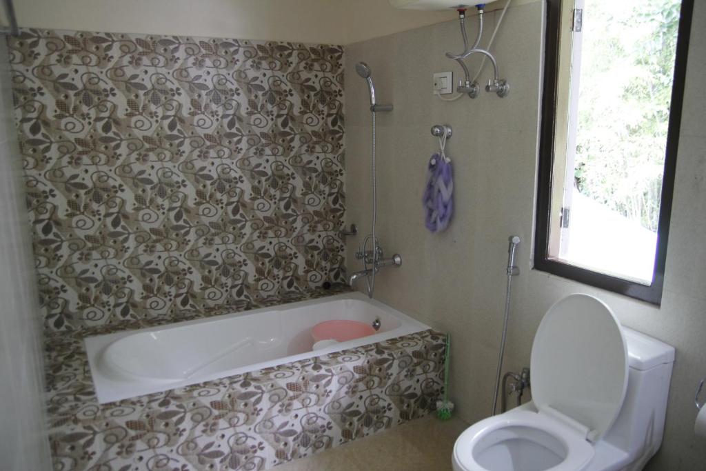 bagno con vasca e servizi igienici di Vamoose Gomethang Homestay a Sosing