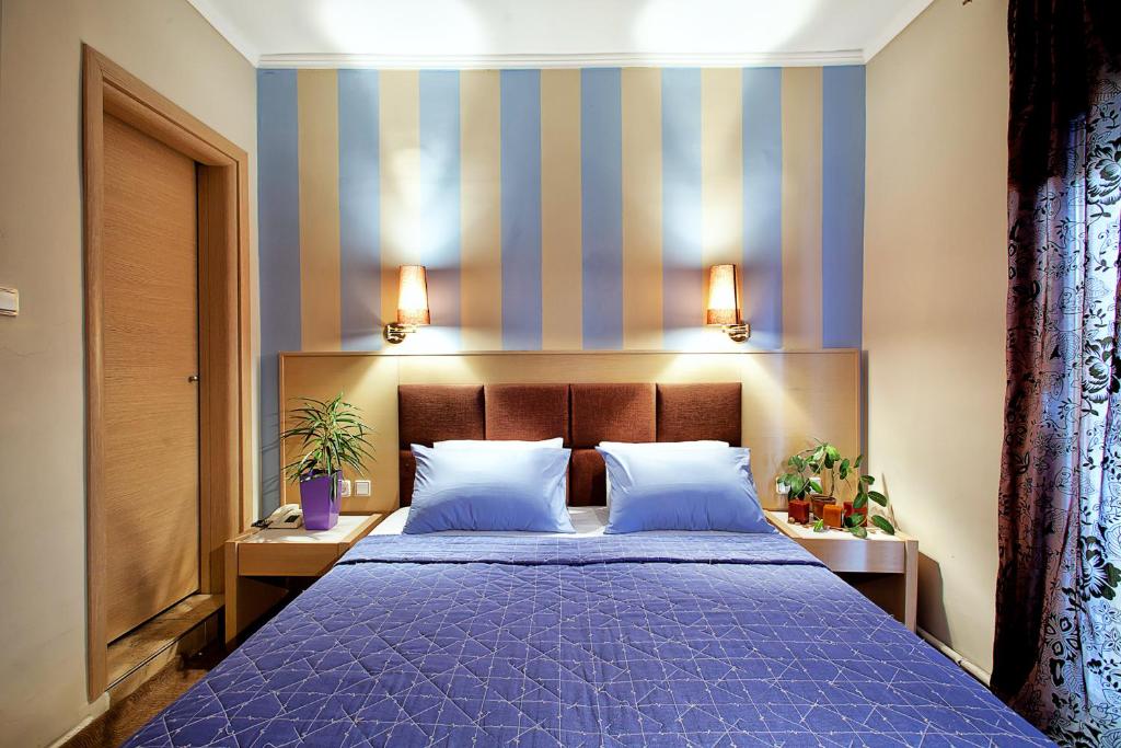 a bedroom with a purple bed with two pillows at Anastassiou Hotel in Kastoria