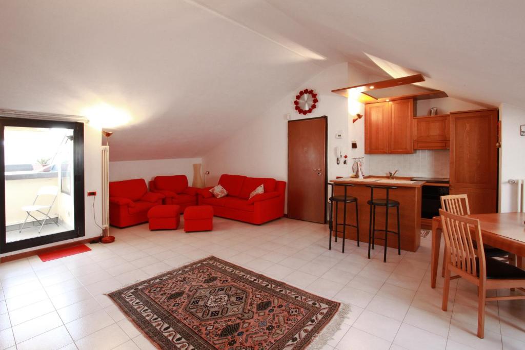 sala de estar con sofá rojo y cocina en Casa Vacanze Margarita, en Bérgamo