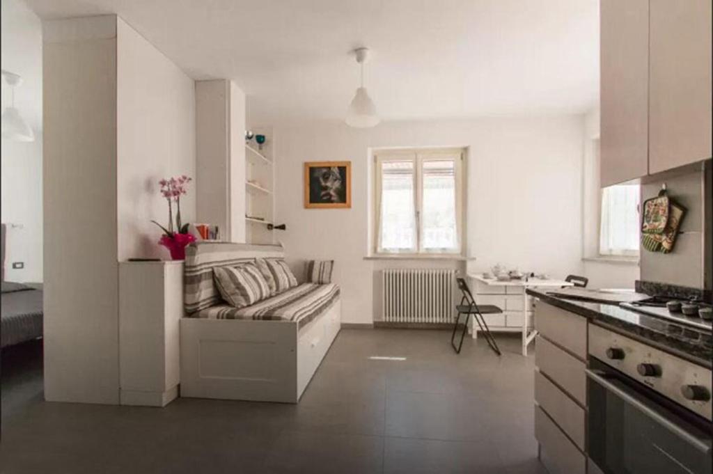 a white living room with a couch and a kitchen at Casa dei Marmi - in Toscana 10 min dal mare in Massa