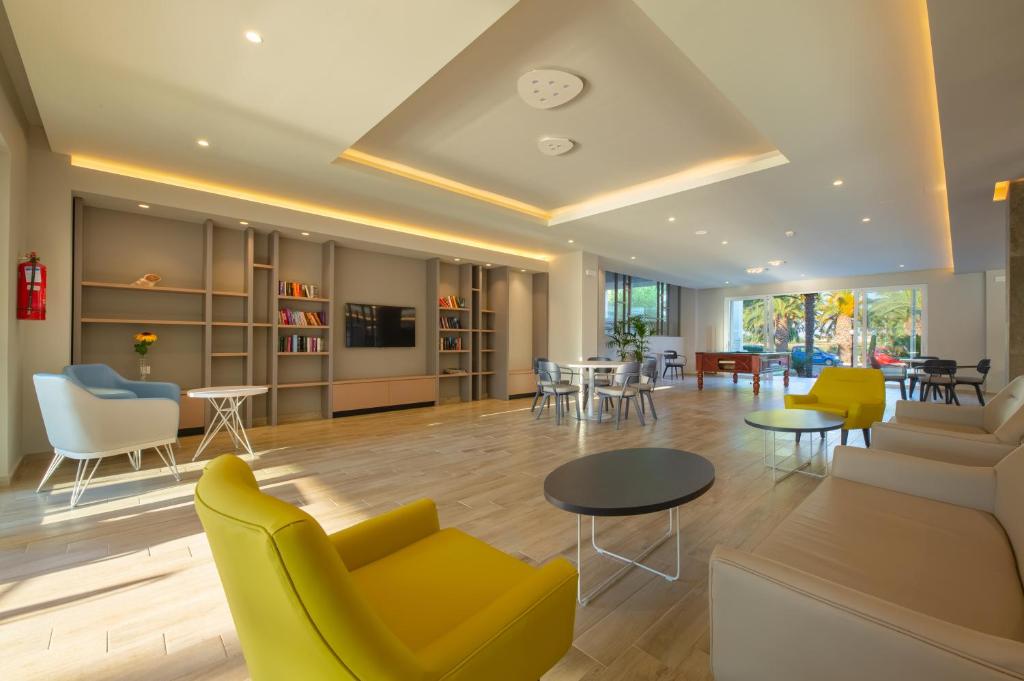 Hotel Esperia في مارماري: غرفة معيشة مع كراسي وطاولات صفراء