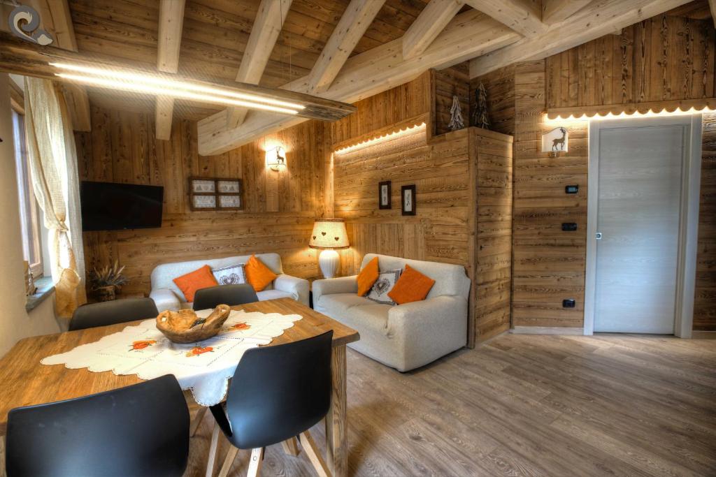 uma sala de estar com uma mesa e um sofá em Appartamento Mirtillo - CIR 0045 em Pré-Saint-Didier