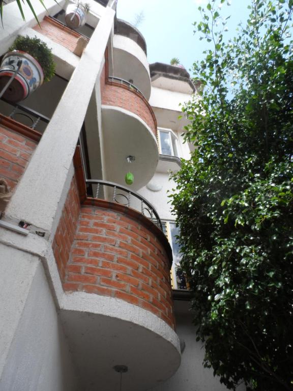 - un bâtiment en briques avec un balcon sur le côté dans l'établissement Hotel Internacional Malitsin, à Guanajuato