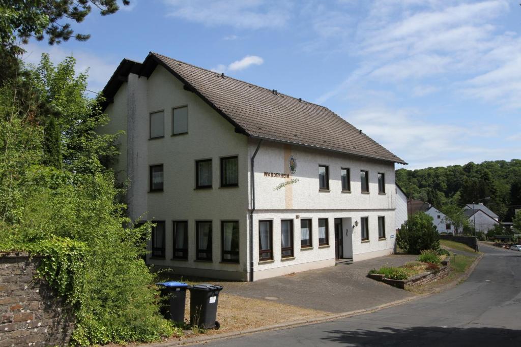 ein großes weißes Gebäude mit Fenstern auf einer Straße in der Unterkunft Ferienhaus Vulkaneifel Kopp in Kopp