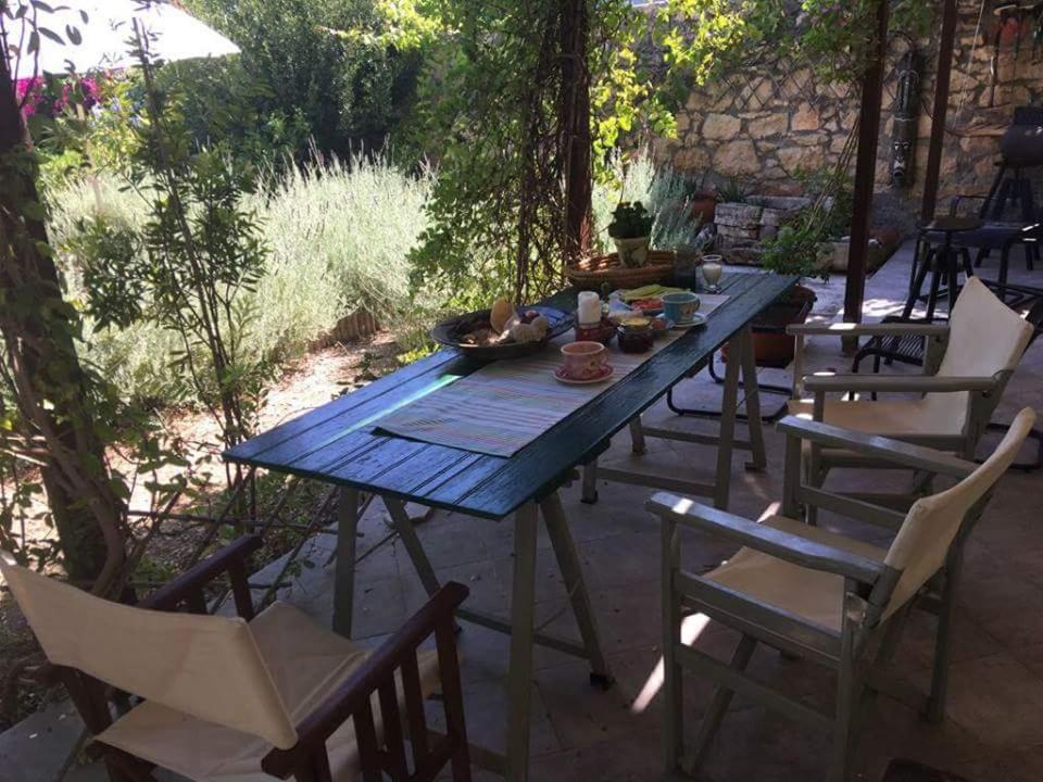 een blauwe picknicktafel en stoelen in een tuin bij Aegina's Oasis in Aegina Town