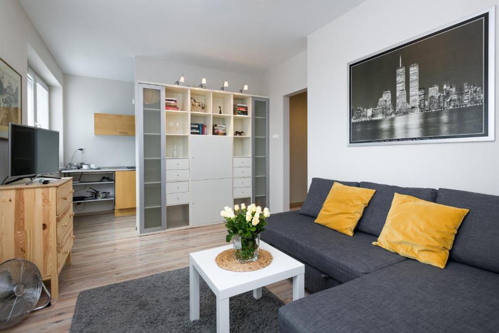 uma sala de estar com um sofá e uma mesa em Sunny 1 room apartment with the view over Cracow em Cracóvia
