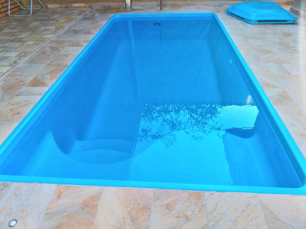 uma piscina com uma banheira azul num quarto em Casa de Temporada "Play Art" em Olímpia em Olímpia