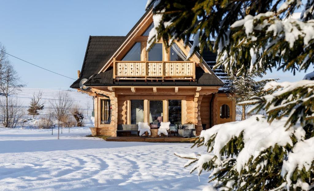 a log cabin in the snow with a balcony at Stylowa Chata in Zakopane