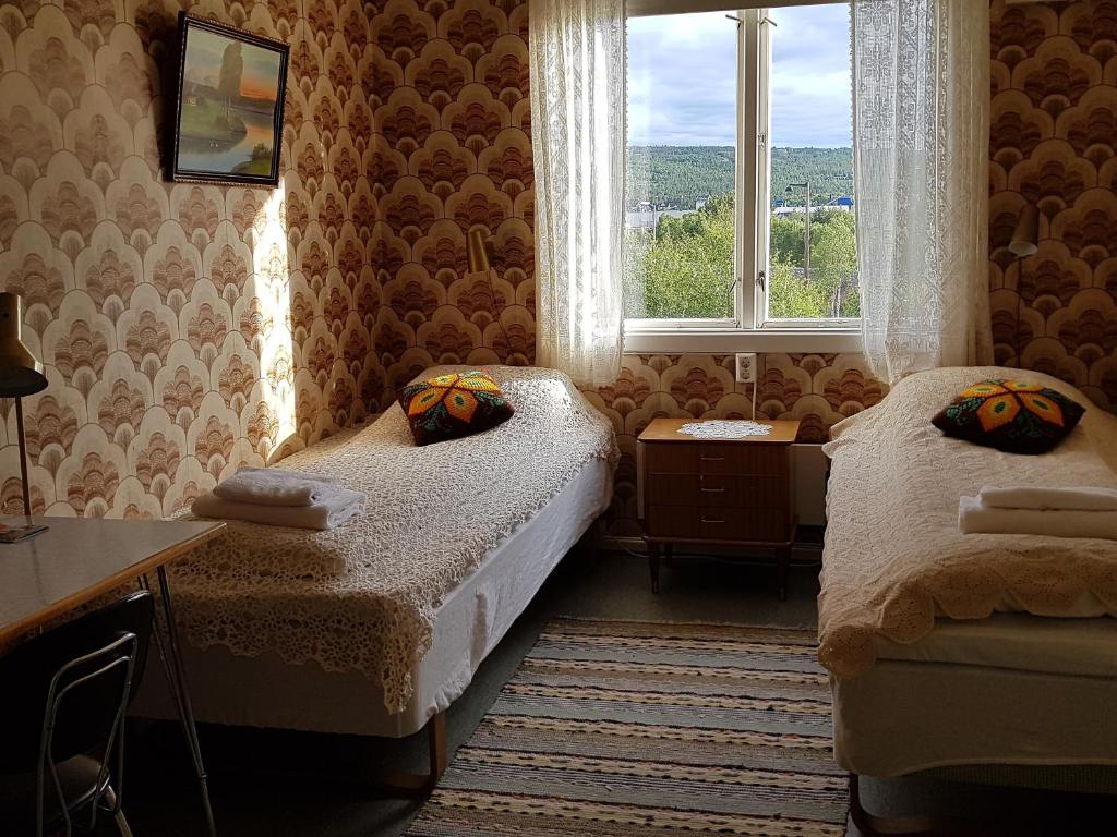 a small room with two beds and a window at Solheim Pensjonat in Røros