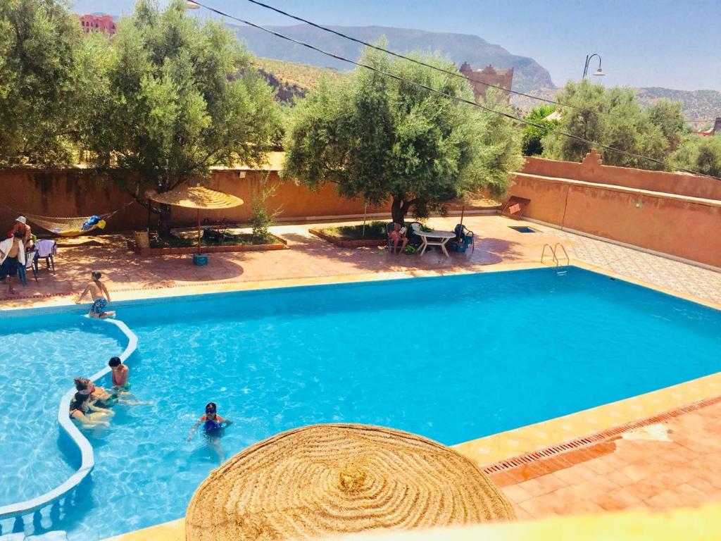a swimming pool with people playing in the water at Hotel France Ouzoud in Ouzoud