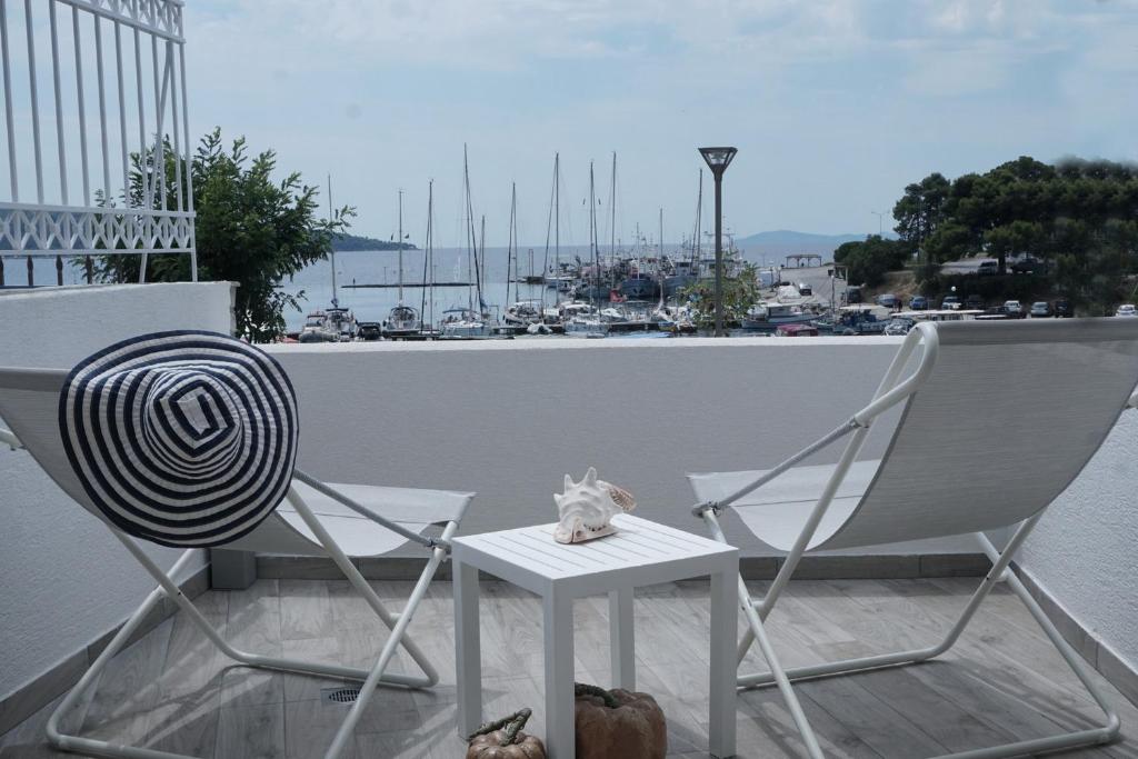 a cat sitting on a table next to two chairs at Aqua Marine in Neos Marmaras