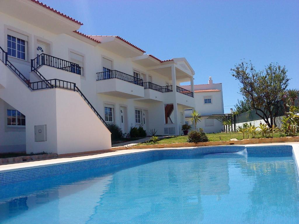 a swimming pool in front of a house at RC - Pata Residence in Albufeira