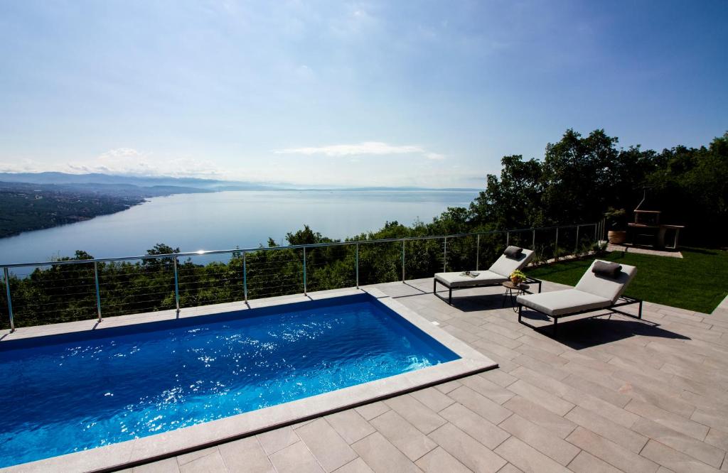 a swimming pool on a patio with a view of the water at Villa vista sul Quarnero in Matulji