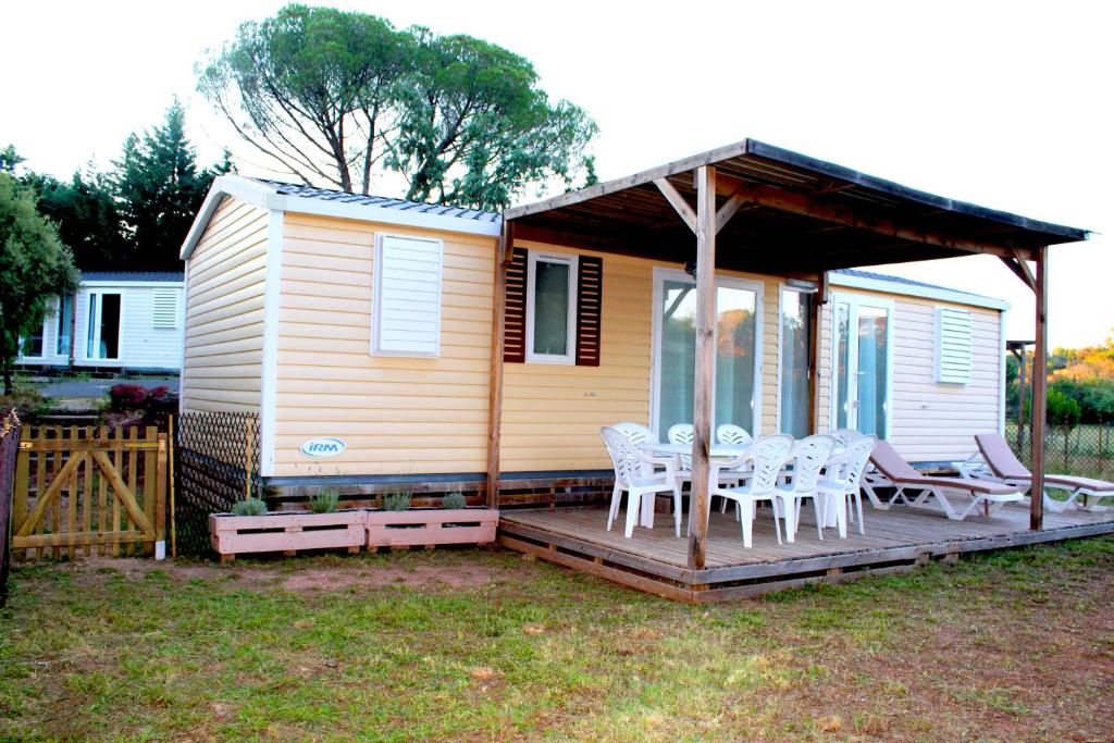 ein Haus mit einer Terrasse mit Stühlen und einer Veranda in der Unterkunft Mobil home florida - camping les cigales - 4 étoiles in Le Muy