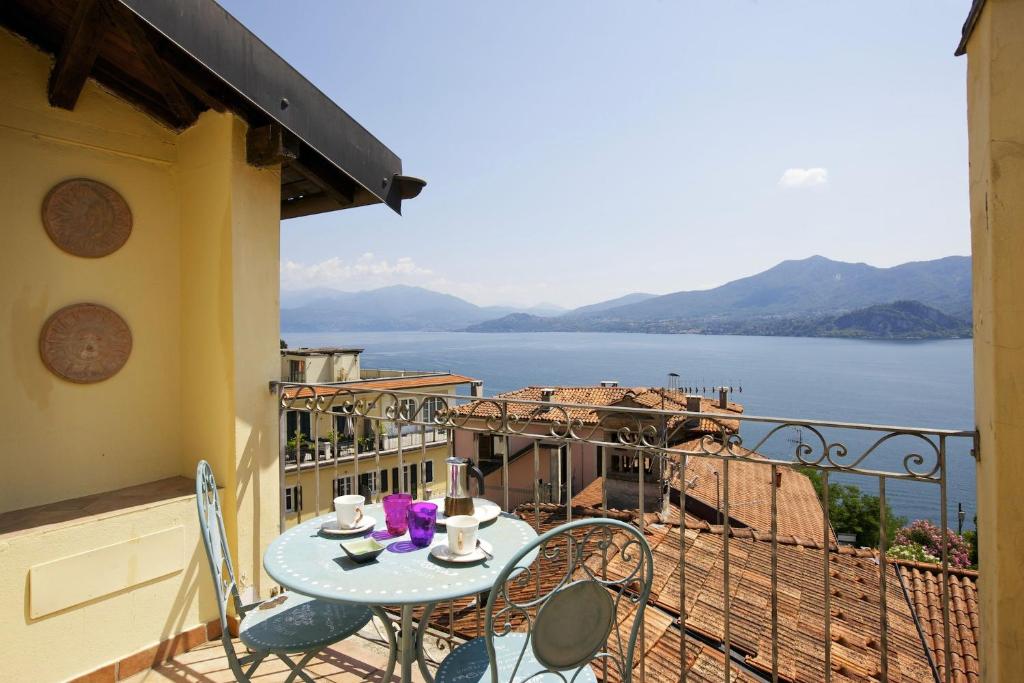 a table and chairs on a balcony with a view of the water at Appartamento Ronco in Ghiffa