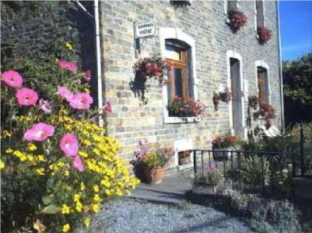 uma casa de tijolos com flores em frente em Les Vieilles Pierres em Comblain-au-Pont