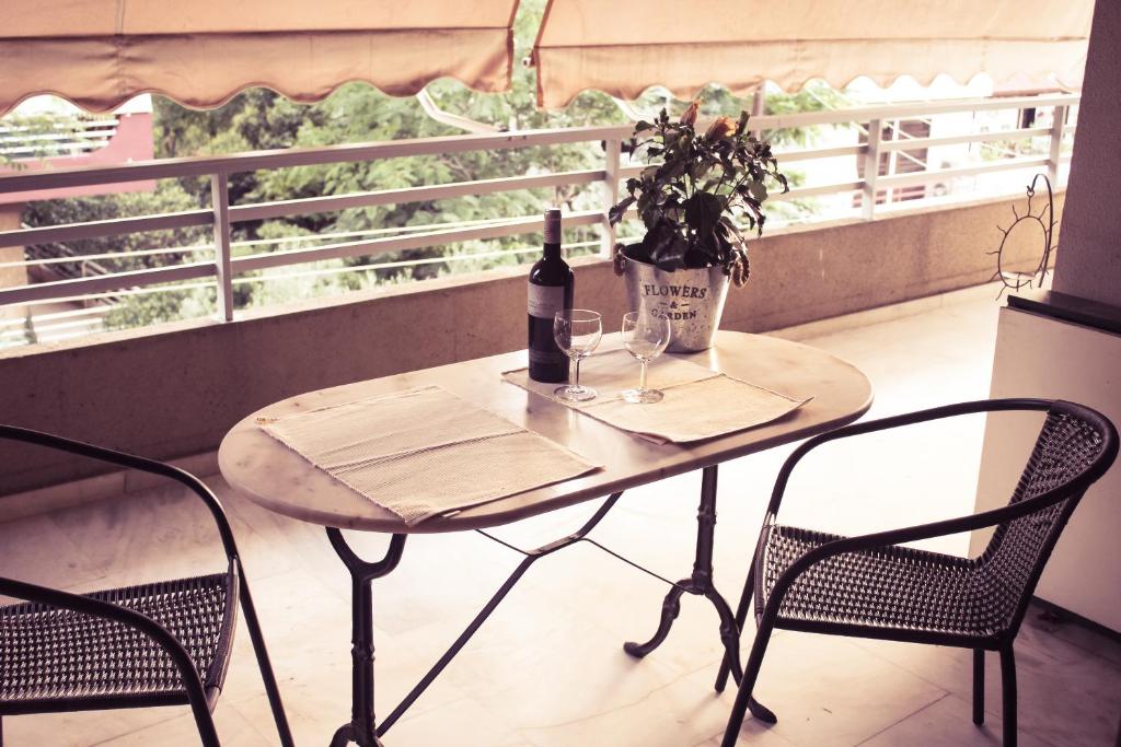 un tavolo con una bottiglia di vino e due sedie di City Break Nearby Metro And Bus Express Airport ad Atene