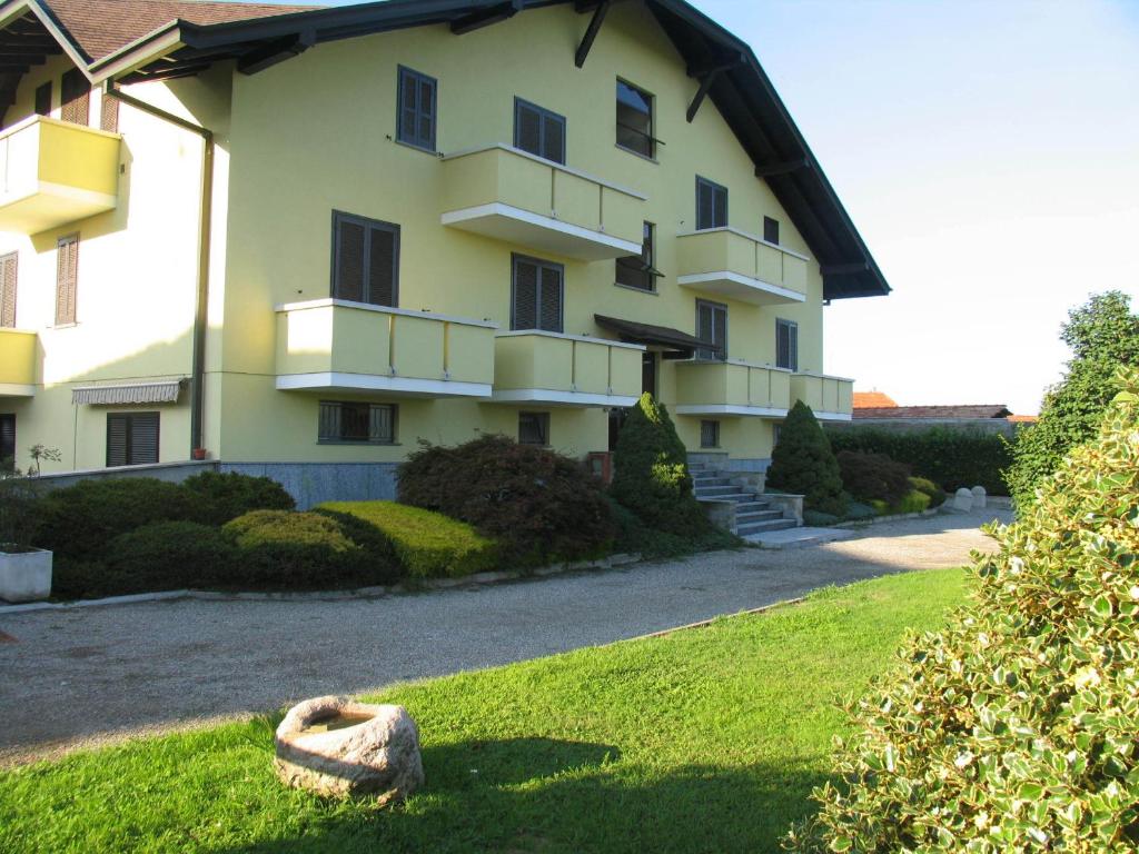 um grande edifício com um quintal relvado em frente em Albergo Residence Isotta em Veruno