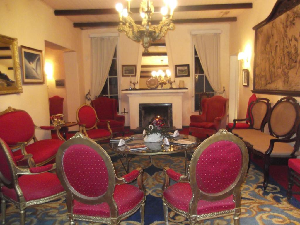 a living room with chairs and a table and a fireplace at Estancia El Rosario in Melo