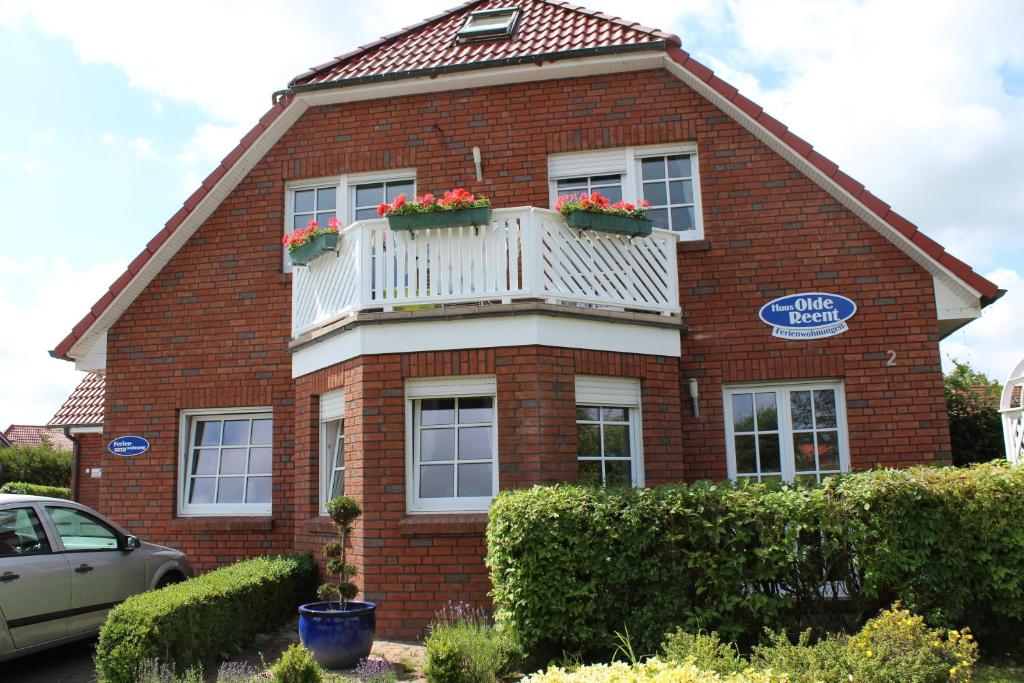 a red brick house with a balcony with flowers on it at Seestern in Werdum