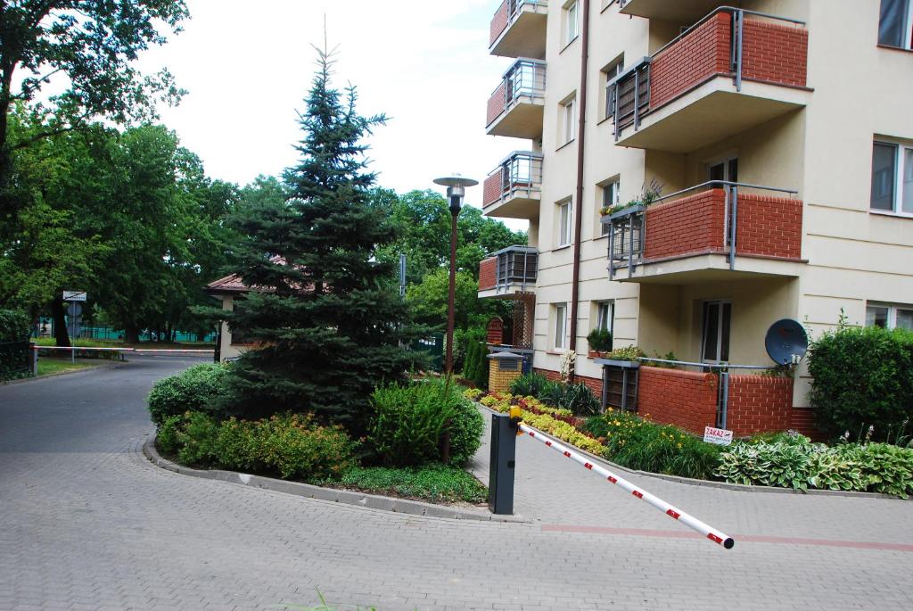 a building with a tree on the side of a street at Kasztanowa Apartament in Warsaw