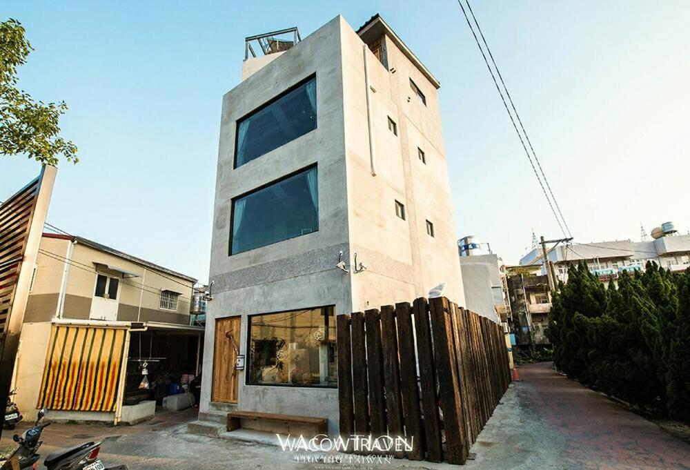 een hoog gebouw met glazen ramen aan een straat bij Pin Shiuan Inn in Xiaoliuqiu