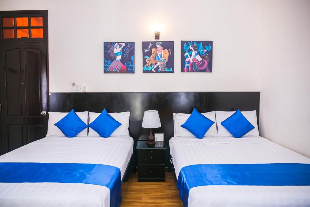 1 dormitorio con 2 camas con sábanas azules y blancas en Blue Star Hotel, en Nha Trang