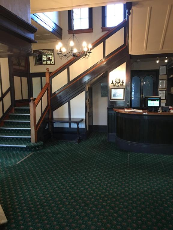 a lobby with a staircase and a bar in a building at The Kamo Hotel in Whangarei