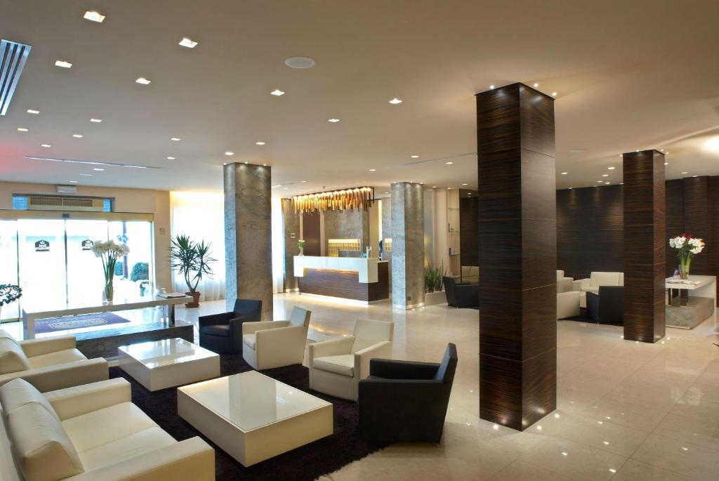 un vestíbulo con sofás blancos y mesas en un edificio en Best Western Hotel Tre Torri, en Altavilla Vicentina