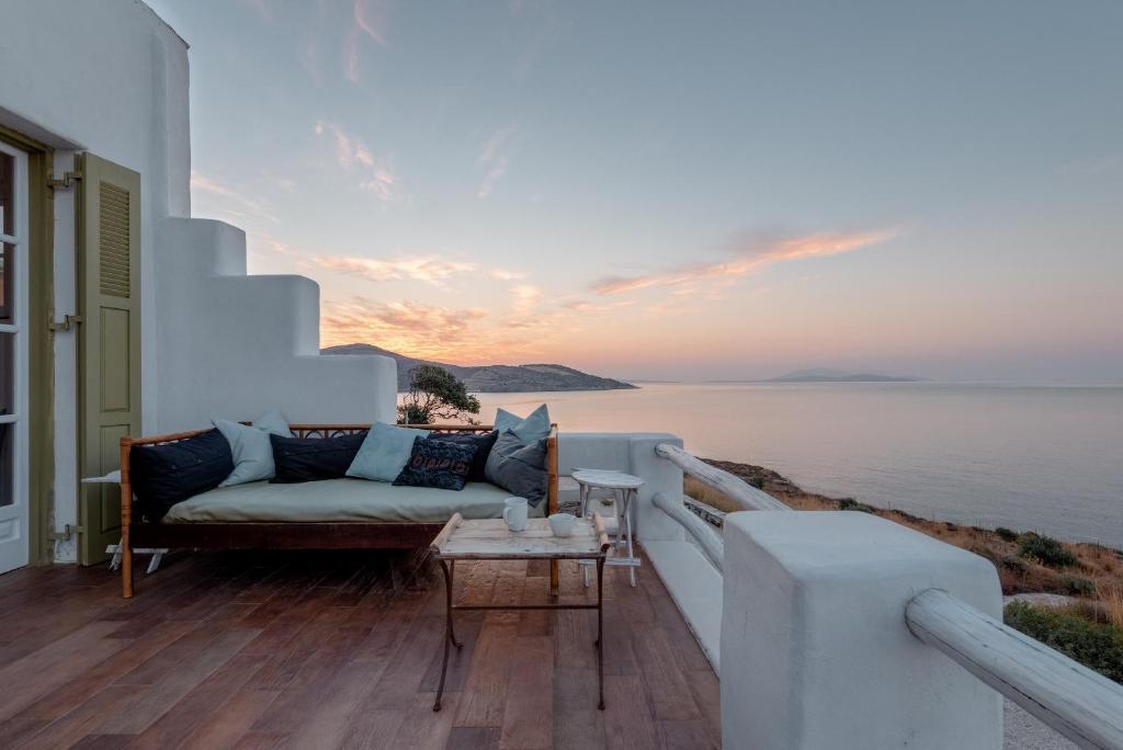 a balcony with a couch and a view of the ocean at Panasea Villa Naxos in Kalando