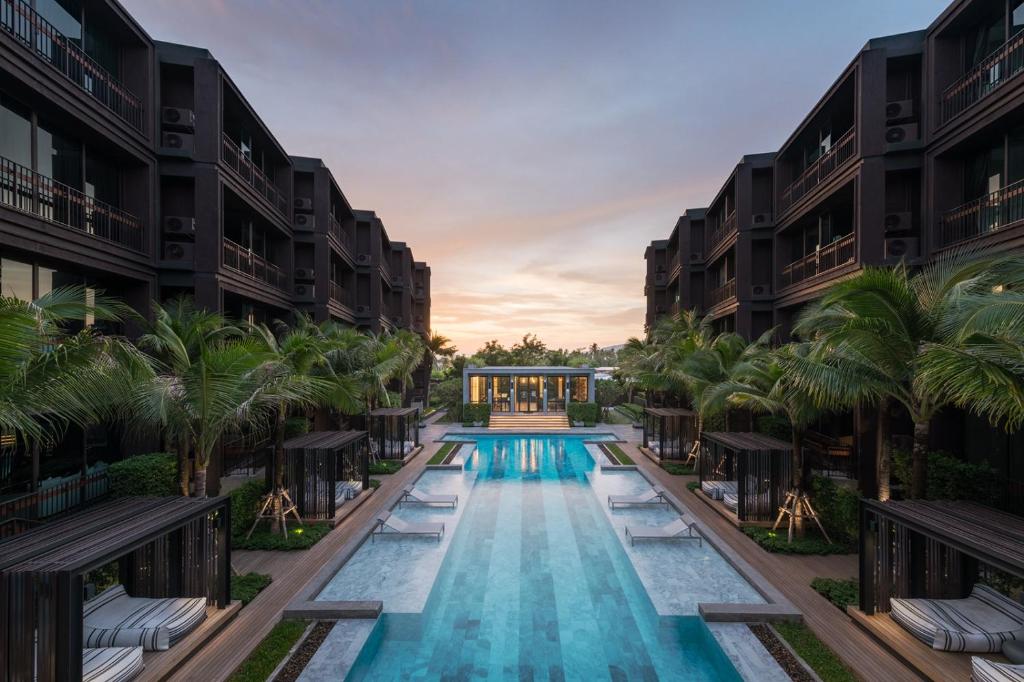 uma imagem de uma piscina num resort com palmeiras em OneBedroom with Balcony at Saturdays Residence em Rawai Beach