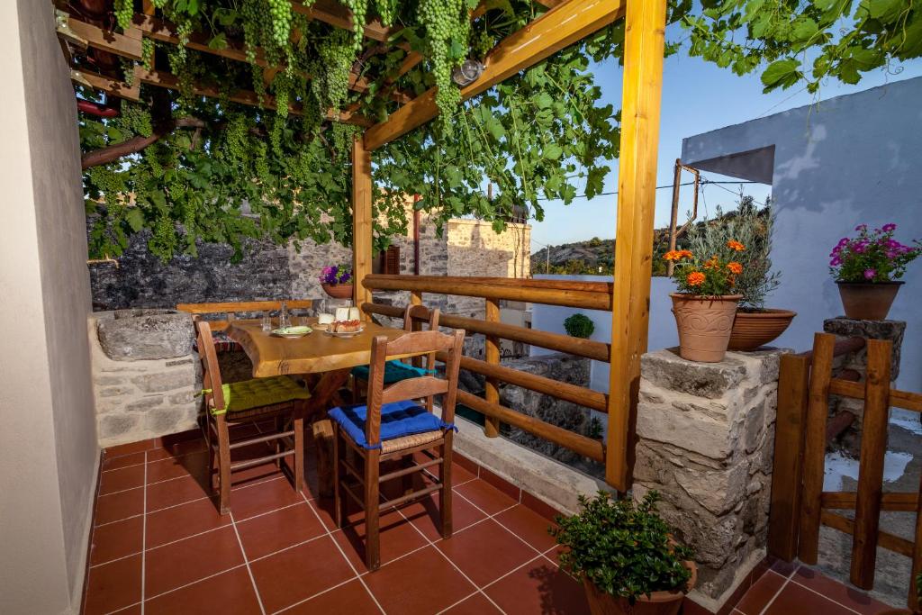 a patio with a table and chairs on a balcony at ARISTIDIS'S PLOUTI MOIRES in Ploutí