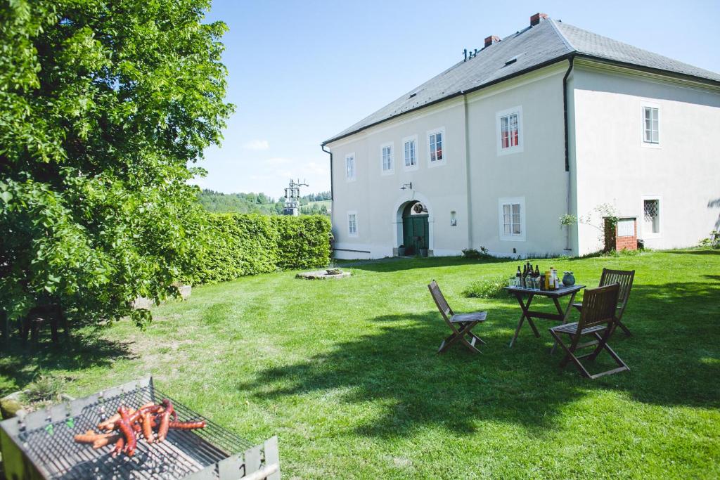 une arrière-cour avec une table et des chaises et un bâtiment dans l'établissement Barokní fara Český ráj, à Železný Brod