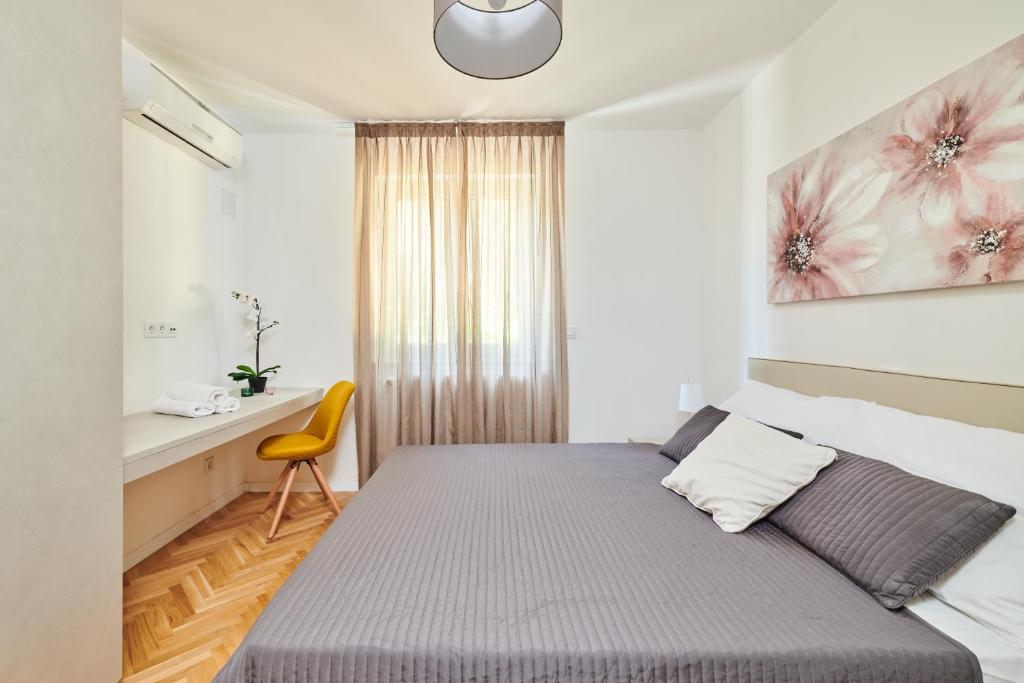 a small bedroom with a bed and a desk at Ribarska Koliba - Villa Marija in Pula