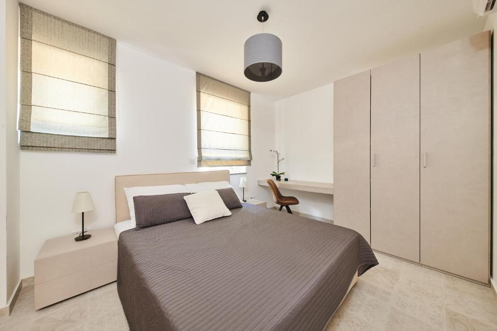 a bedroom with a large bed and a chair at Ribarska Koliba - Villa Marija in Pula