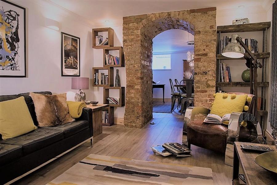 a living room with a couch and an archway at Havisham House in Woburn