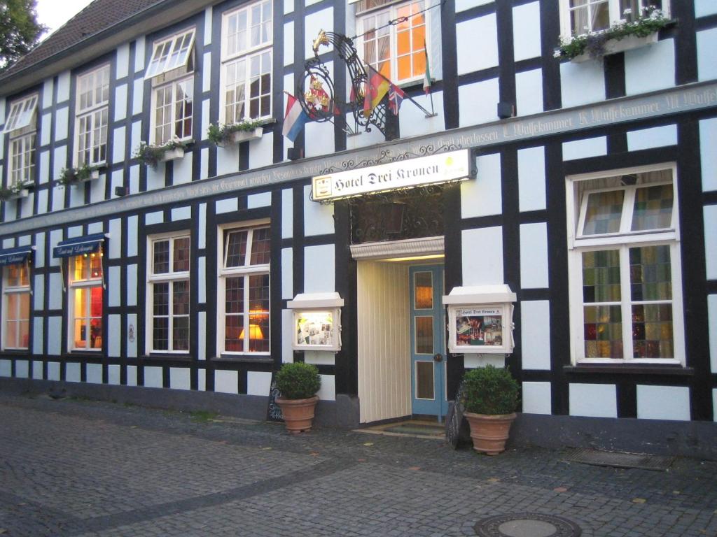a black and white building with a sign on it at Hotel Drei Kronen in Tecklenburg