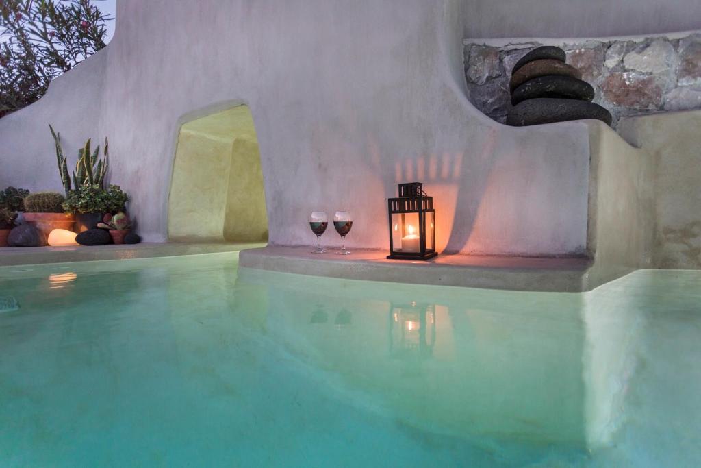 a swimming pool with a candle and two glasses of wine at Canava Villas #2 in Santorini Private Pool in Emporio