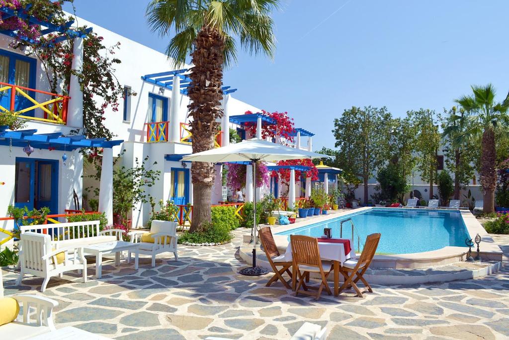 un complejo con piscina, sillas y una palmera en Su Hotel - Bodrum, en Bodrum City