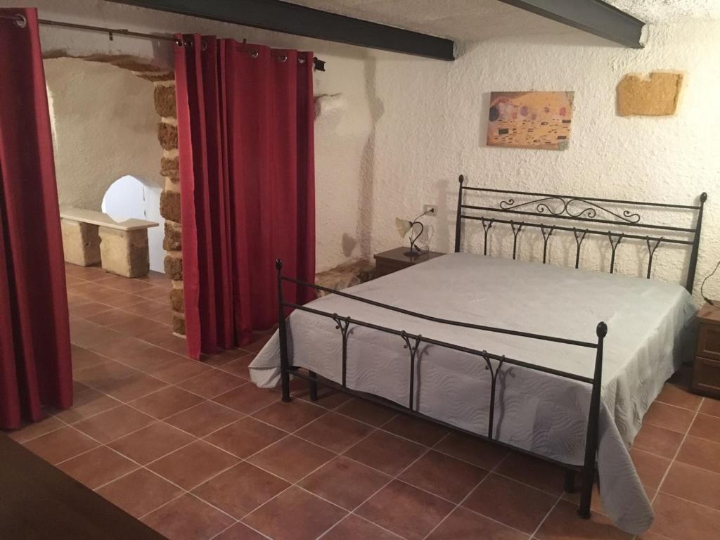 a bedroom with a bed and a red curtain at Terra del Sole Ribera in Ribera